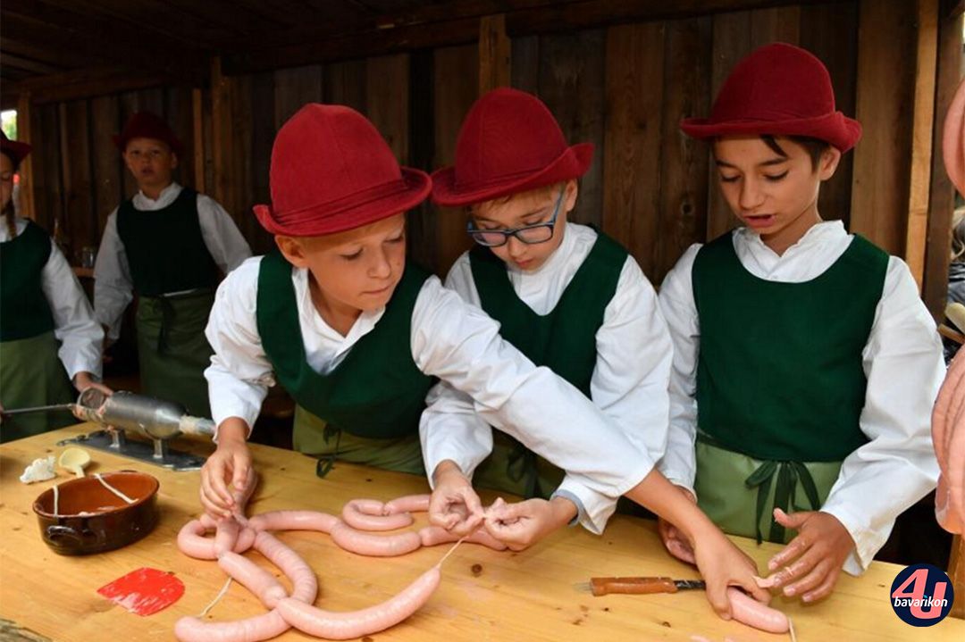 Kinder der Metzgerzunft machen Würste