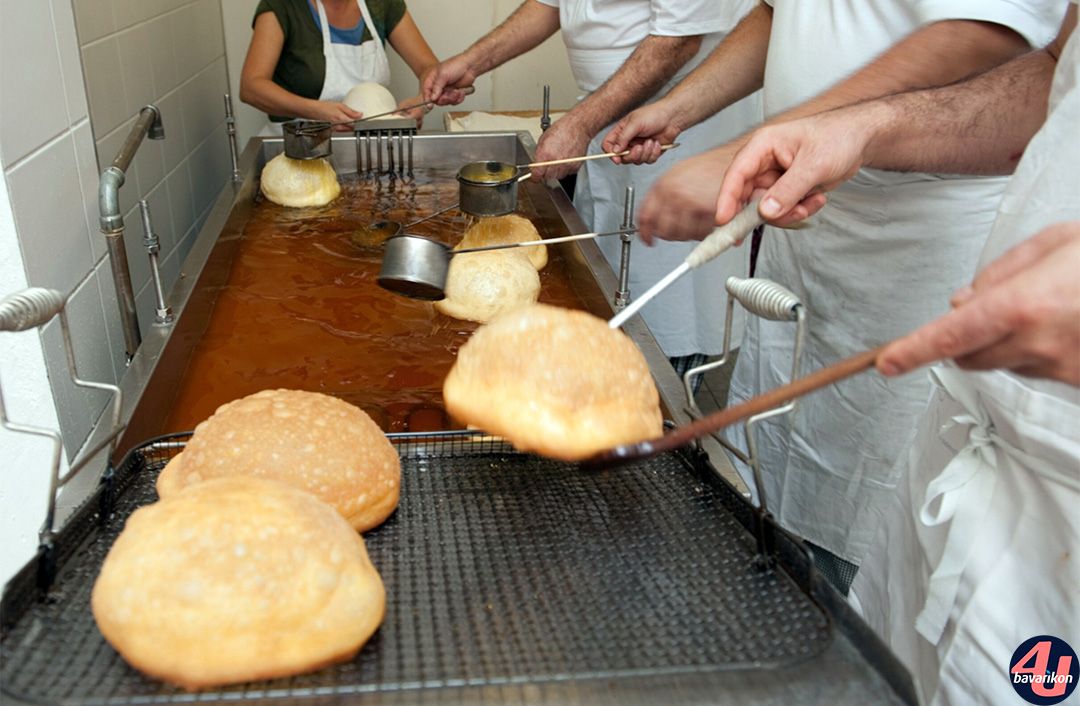 Fertig gebackener Hutkrapfen wird aus dem Öl genommen